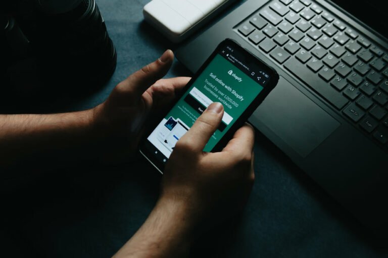 hands-hold-a-cellphone-showing-the-shopify-partner-home-page